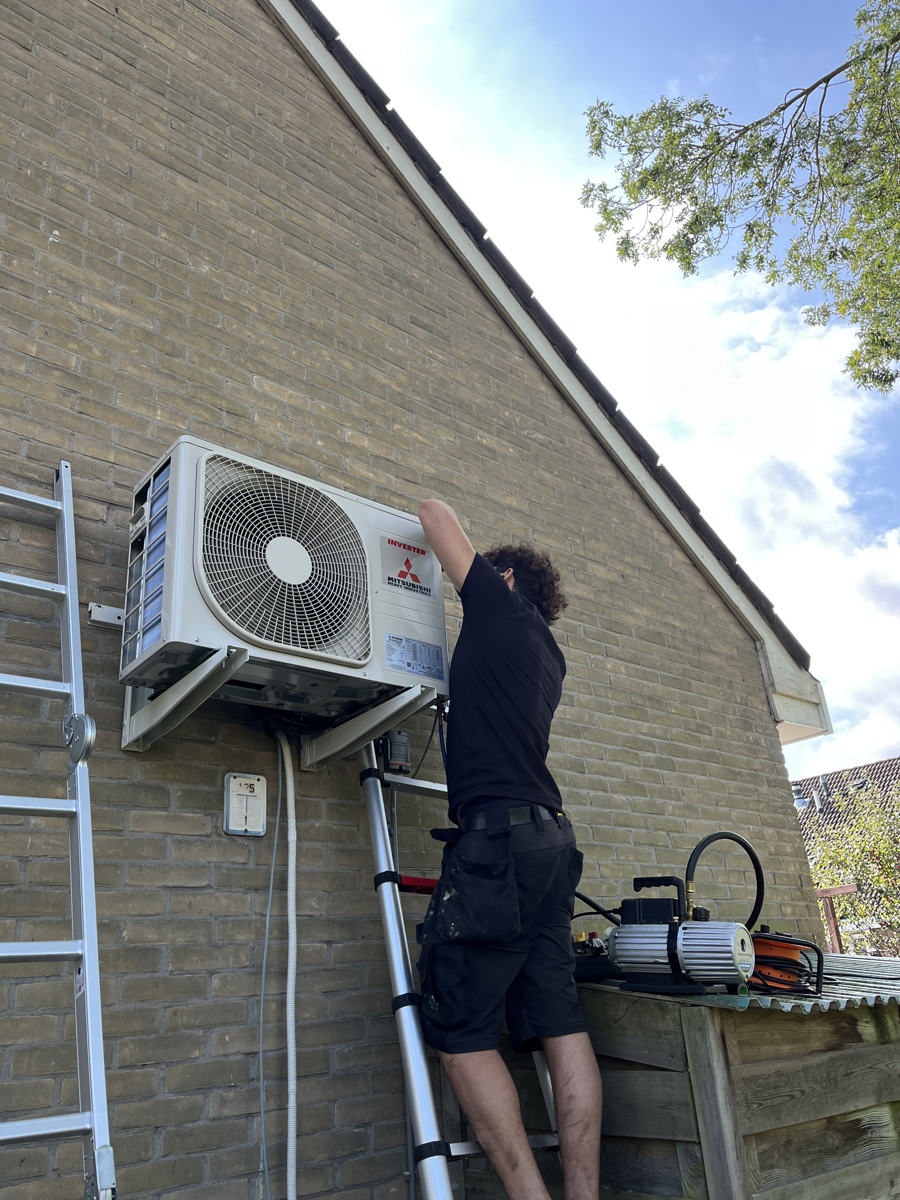 Technicus installeert een airconditioner in een woonhuis in Lemmer, Friesland